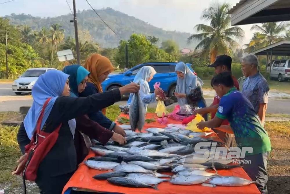 Orang ramai yang datang bagi mendapatkan ikan tongkol pada harga RM5 seekor.