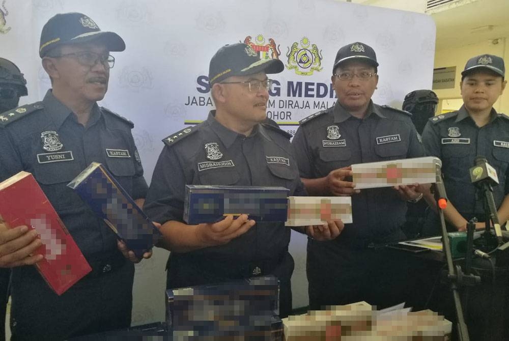 Misbahudin (tengah) menunjukkan rokok putih yang dirampas pihaknya, selepas sidang akhbar di Kompleks Penguatkuasaan Kastam Sungai Pulai, Iskandar Puteri, pada Khamis