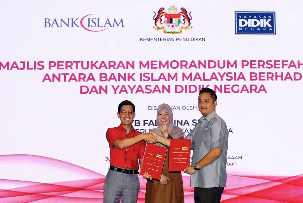 Fadhlina (tengah) menyaksikan pertukaran memorandum persefahaman (MoU) antara Ketua Pegawai Eksekutif Kumpulan Bank Islam Mohd Muazzam Mohamed (kiri) dan Ketua Pegawai Eksekutif Yayasan Didik Negara, Hardian Hadir (kanan) pada Jerayawara Pendidikan Madani pada Jumaat. - Foto: Bernama