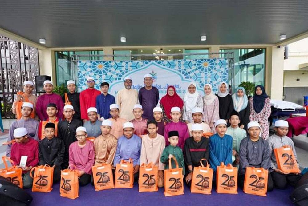 Najmuddin (tengah, belakang) bersama anak-anak yatim dan tetamu jemputan majlis berbuka puasa anjuran PBT itu pada Jumaat.