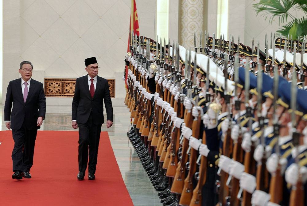 Perdana Menteri, Datuk Seri Anwar Ibrahim (dua dari kiri) memeriksa kawalan kehormat pada sambutan rasmi yang diadakan oleh Perdana Menteri China, Li Qiang (kiri) di Great Hall of the People, pada Sabtu. - Foto Bernama