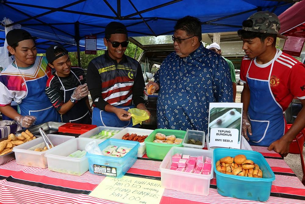 Ab Rauf (dua dari kanan) menyantuni para peniaga pada program Tinjauan Mesra di Bazar Ramadan MITC, pada Sabtu. - Foto Bernama