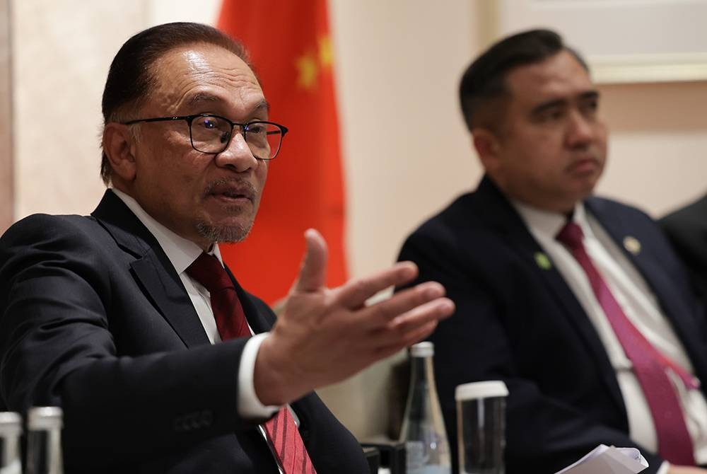 Perdana Menteri, Datuk Seri Anwar Ibrahim pada sidang media bersama para pengamal media dari Malaysia pada hari terakhir lawatan rasminya ke China, pada Sabtu. Turut kelihatan, Menteri Pengangkutan, Anthony Loke (kanan). - Foto Bernama