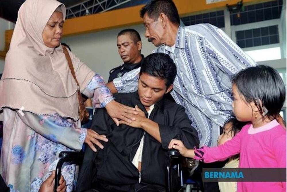 Koperal Mohd Qaiyum yang ketika itu berpangkat Konstabel ditemani ibunya, Hasnah Abdul Manan (kiri) dan bapanya Zolkipli Mohd Sidek (dua dari kanan) ketika tiba di Hangar Pangkalan Latihan Unit Udara Polis, 10 tahun lepas. - Foto fail Bernama