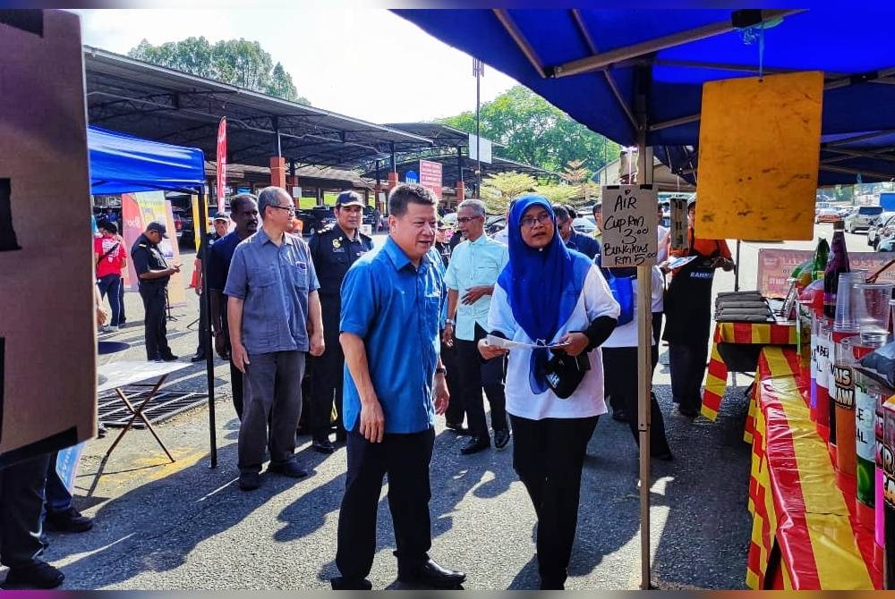 Pengarah KPDN Pahang, Jezlily Jamaluddin (kanan) bersama pegawai mengiringi Exco Perdagangan Dalam Negeri dan Sumber Manusia Negeri Pahang, Sim Chon Siang adakan lawatan dan pemeriksaan harga Menu Rahmah di Bazar Ramadan Lurah Semantan Temerloh baru-baru ini.