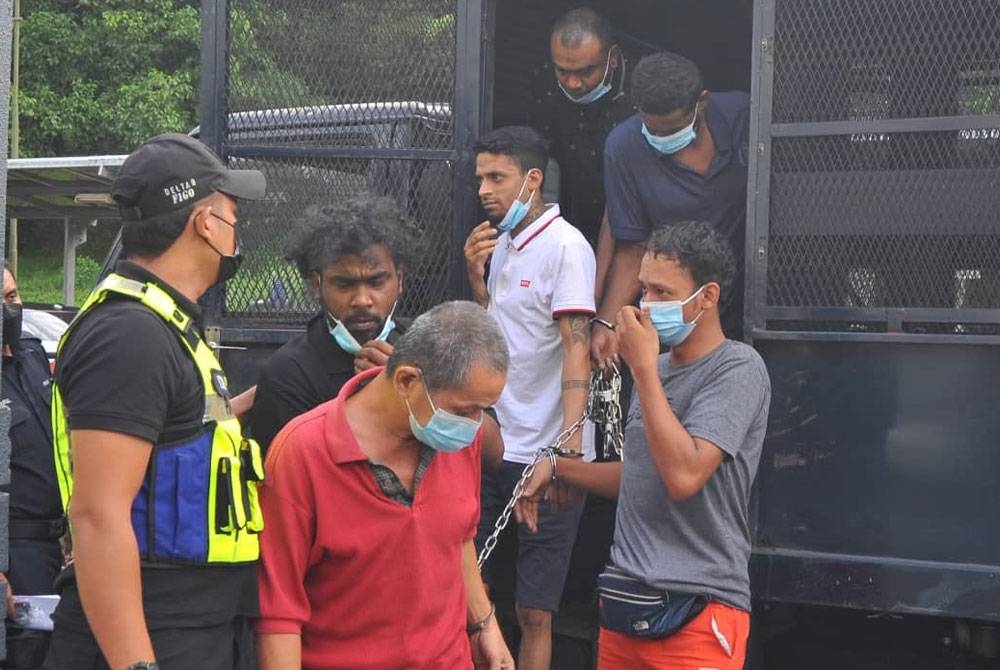 Saravanan (belakang, kiri), ketika tiba di Mahkamah Sesyen, pada Ahad.