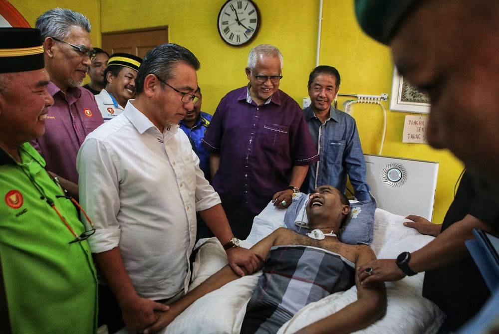 Adly (dua dari kiri) ketika menziarahi veteran ATM Masrizal yang terlantar kerana menghidap penyakit Systemic Lupus Erythematosus (SLE) di kediamannya di Kampung Masjid Hujung, Hutan Kampung pada Ahad.