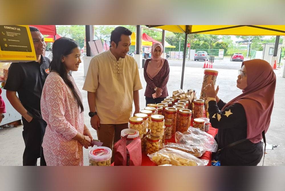 Najwan meninjau gerai menjual biskut raya Bazar Raya Amal Ehsan di Pasar Muhibbah Setia Alam pada Ahad.