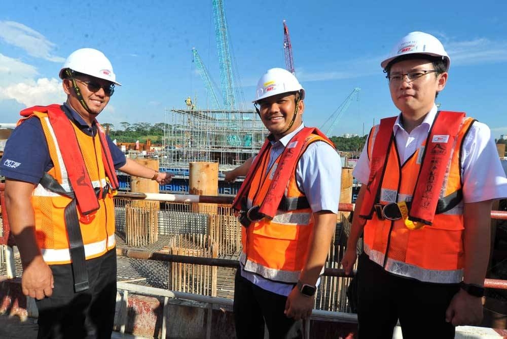 Mohamad Fazli (dua dari kanan) dan Ting Han (kanan) meninjau tapak projek RTS di Stulang Laut, pada petang Selasa.