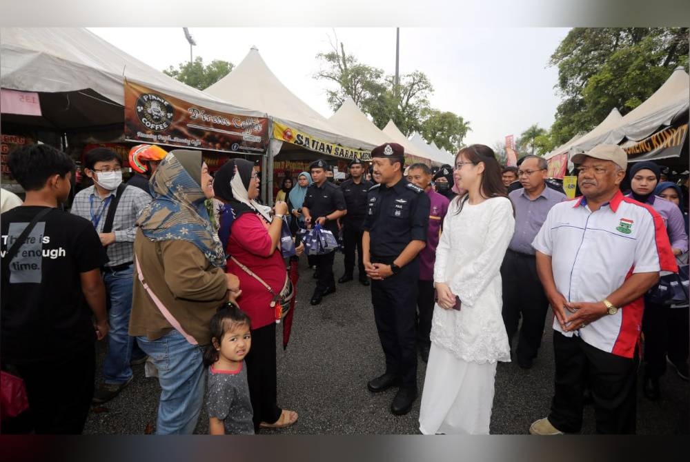 Mohd Yusri (tiga dari kanan) beramah mesra dengan orang ramai sempena Program High Profile Policing (HPP) di bazar Ramadan pekarangan Stadium Perak di Ipoh pada Rabu.