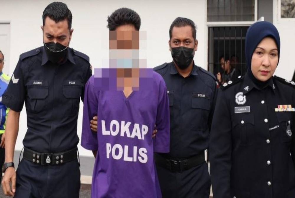 Suspek yang memakai pakaian lokap berwarna ungu tiba di mahkamah pada jam 8.42 pagi dengan diiringi anggota polis. - Foto Bernama