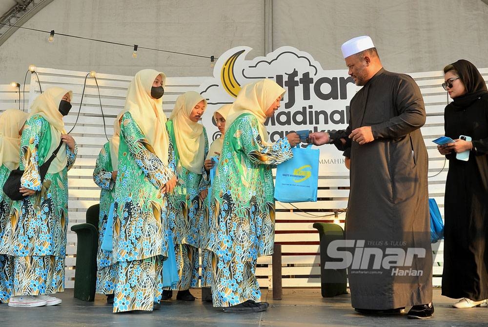 Ramli (dua dari kanan) menyampaikan sumbangan duit raya kepada anak yatim dari Pertubuhan Rahoma Darul Fakir.