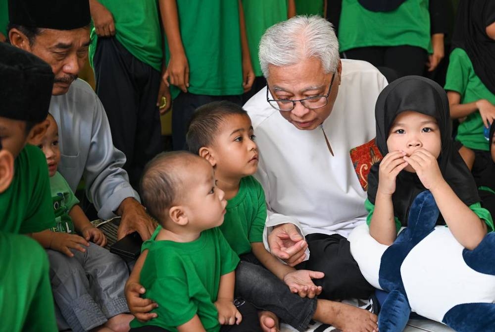 Ismail Sabri ketika menyantuni anak-anak yatim yang juga penghuni Rumah Amal Asnaf Al-Barakh