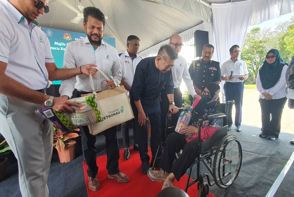 Salahuddin menyerahkan Bakul Rahmah kepada salah seorang penerima melalui Program Memacu Kehidupan: Hari Raya Aidilfitri di Stesen Petronas BKE 2, di sini yang dianjurkan Petronas Dagangan Berhad dengan kerjadama Yayasan Petronas dan Jabatan Kebajikan Masyakat (JKM).