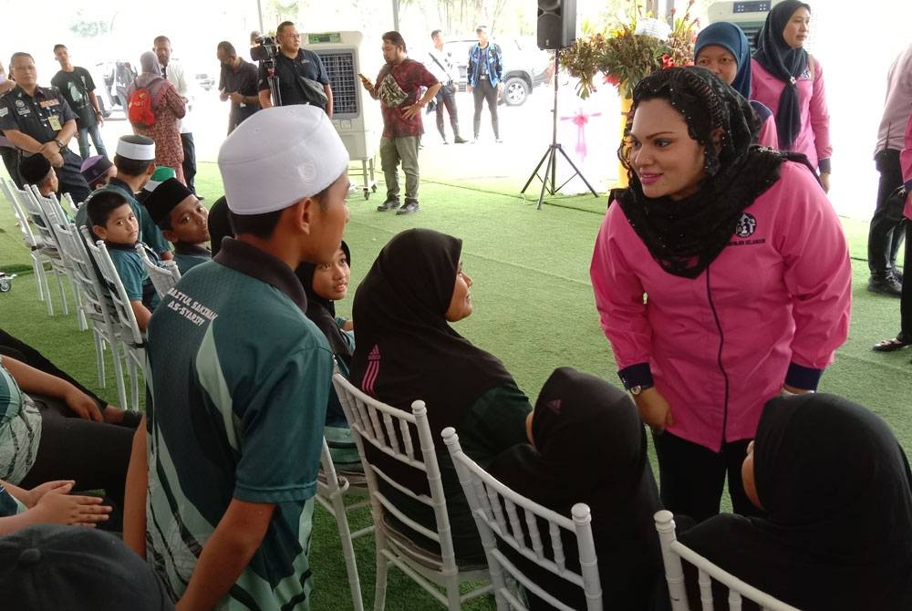 Liliyana Haryanti beramah mesra bersama anak yatim ketika program sumbangan Aidilfitri di gedung tekstil Jakel cawangan Shah Alam, Seksyen 7, pada Jumaat.