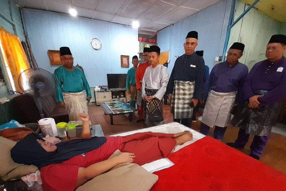 Rohayu kini hanya terbaring di tempat tidur menerima kunjungan Aznan (empat dari kanan) bersama pihak Enproserve dalam Program Ziarah Kasih di Kampung Bukit Raja, Kota Tinggi, pada Jumaat