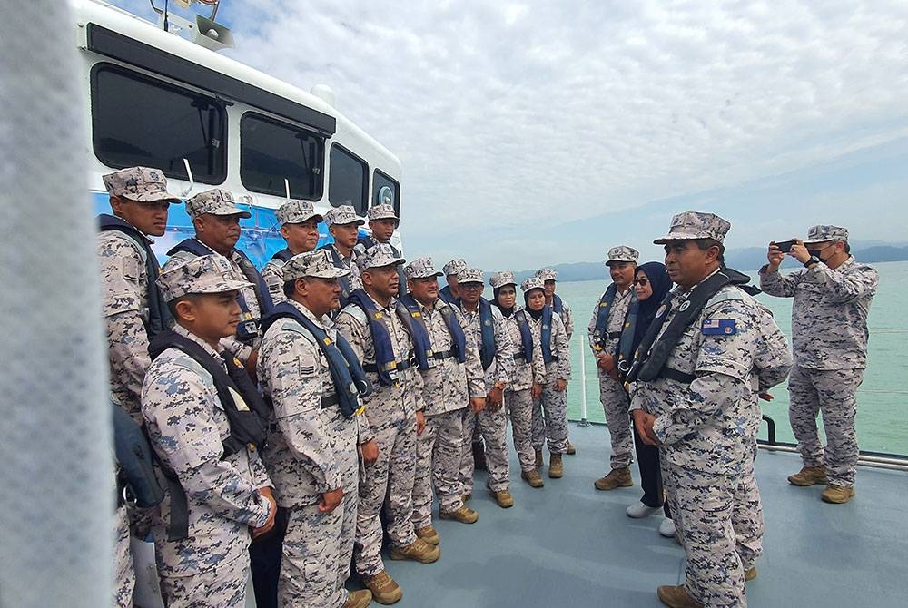 Saiful Lizan (kanan) memberikan kata-kata semangat kepada anggotanya yang akan bertugas pada Op Pagar Laut sempena perayaan Aidilfitri tahun ini.