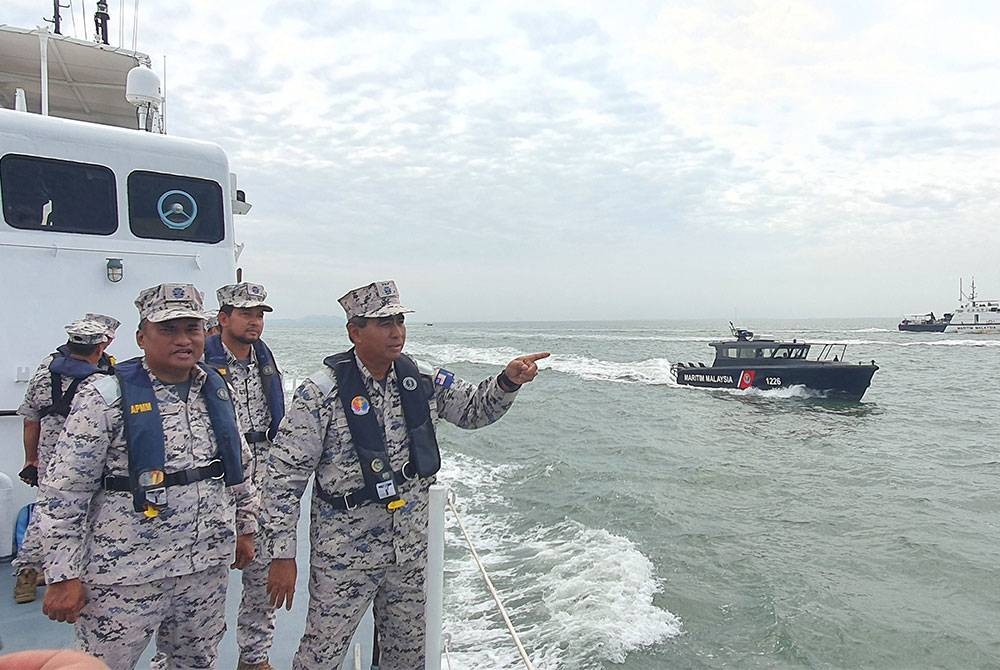 Saiful Lizan (kanan) ketika meninjau OP Khas Pagar Laut yang diaktifkan semula sempena Aidilfitri tahun ini.