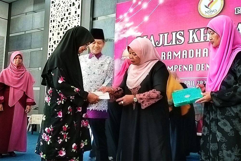 Raja Salbiah (dua dari kanan) menyampaikan infaq kepada penerima di Majlis Tadarus dan Khatam al-Quran Ramadan 1444H/2023 di Dewan Tuanku Aishah Rohani pada Sabtu.