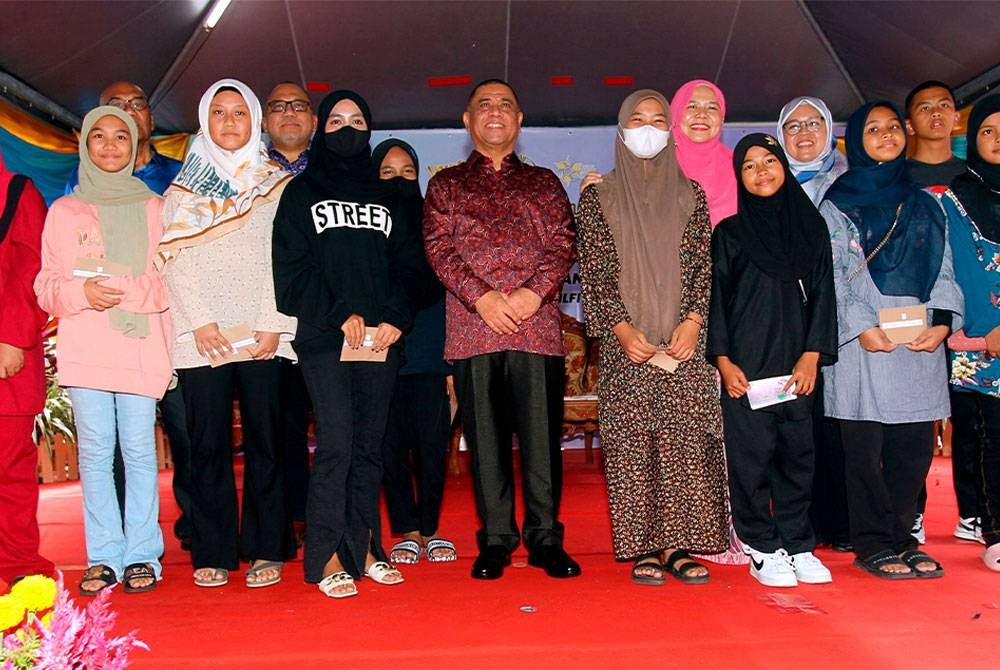 Saarani (depan, tengah) bersama penerima terpilih pada Program Meriah Beraya Sejahtera Bersama di Pusat Pakaian Hari-Hari Cawangan Kamunting pada Sabtu. - Foto Bernama