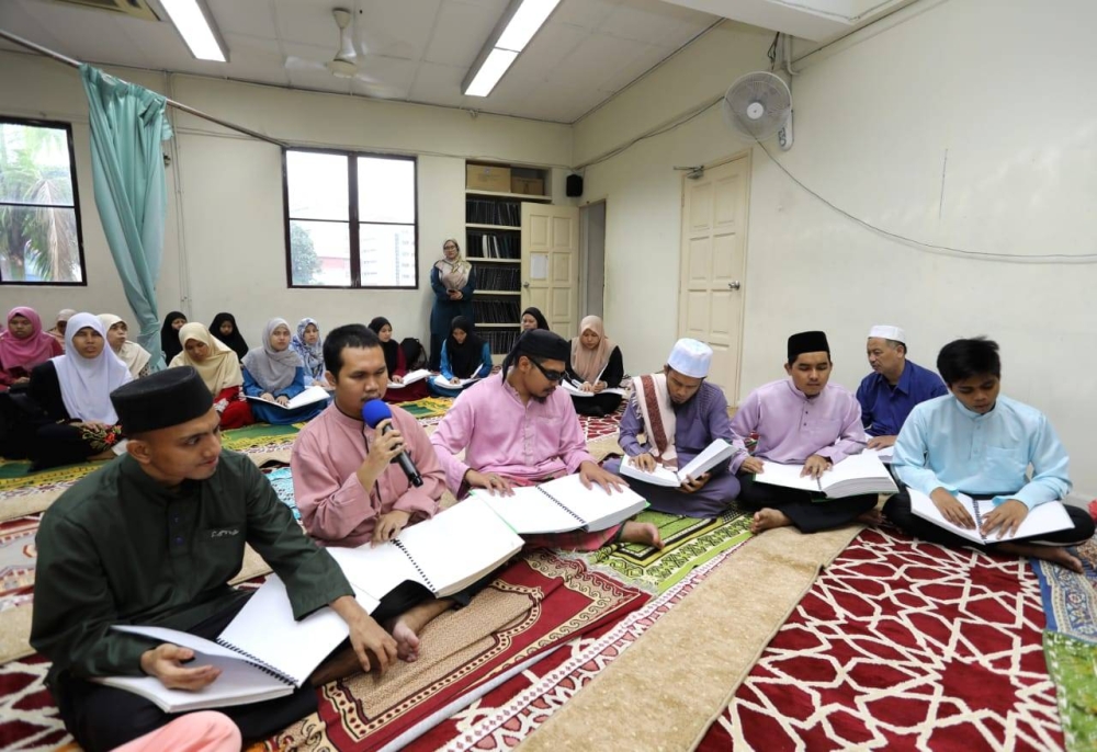 Peserta OKU cacat penglihatan mengalunkan bacaan al-Quran sempena majlis khatam al-Quran pada Sabtu.