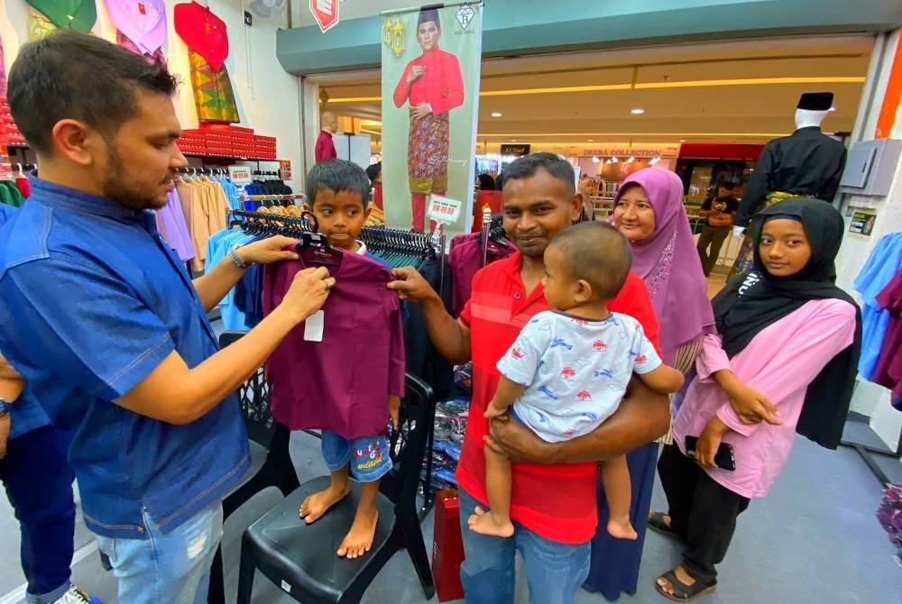 Mohamad Shauti dan keluarga teruja kali pertama menjejak kaki ke pasar raya dan memilih sendiri pakaian baharu untuk Aidilfitri sambil dibantu oleh Murtadhatumizi (kiri).