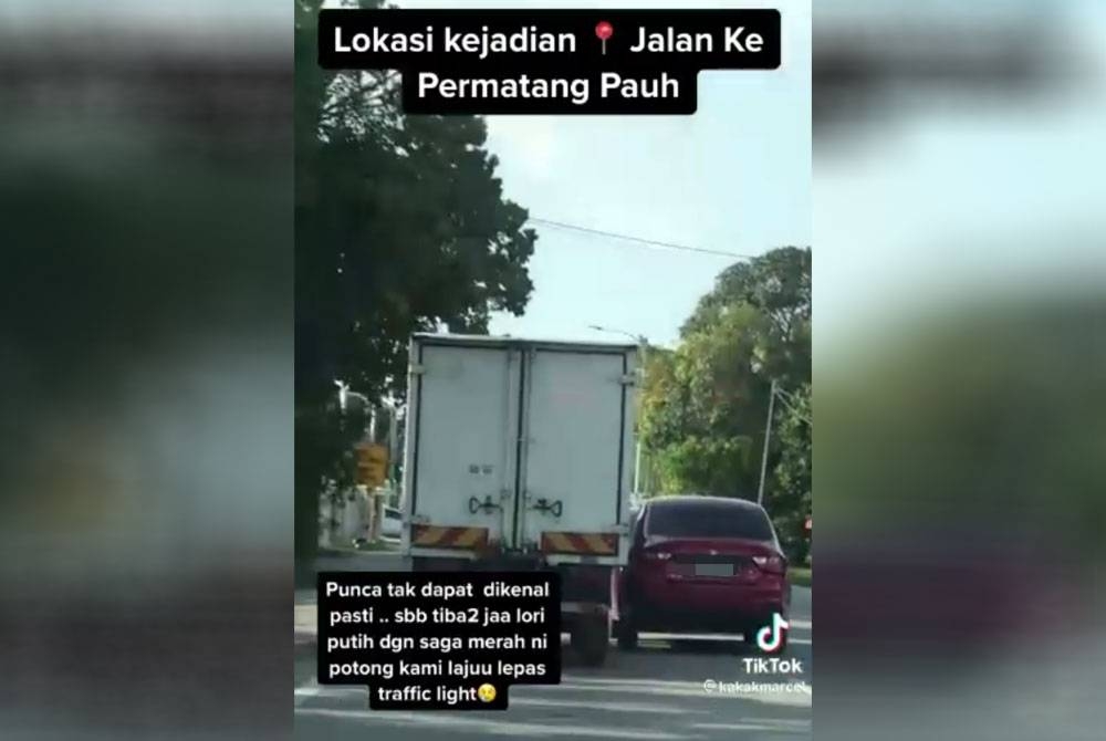 Tangkap layar video tular yang memaparkan aksi himpit-menghimpit antara sebuah kereta dengan lori.