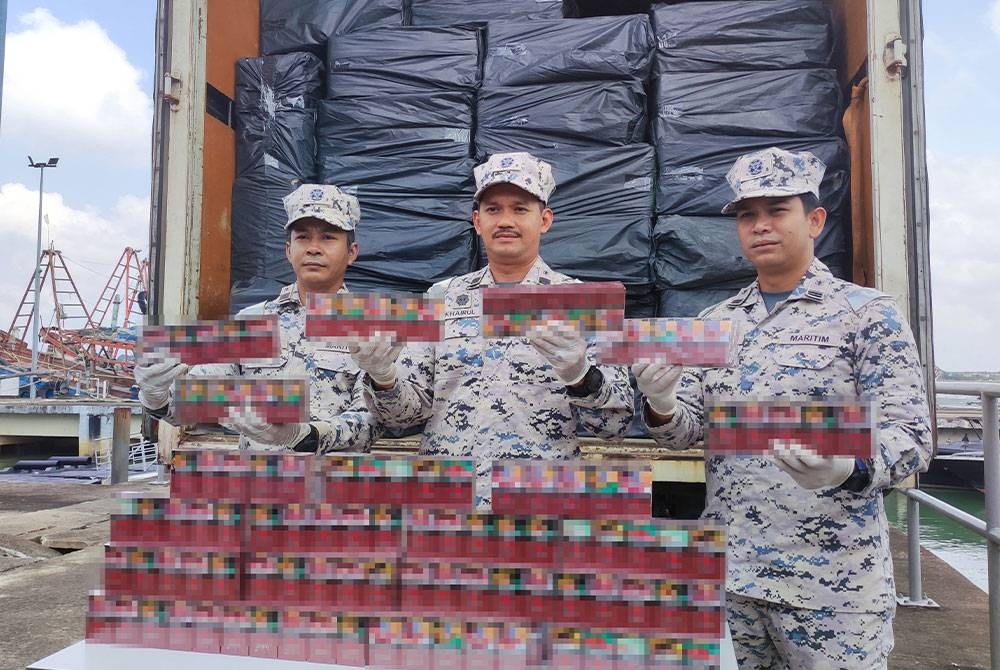 Mohd Khairulanuar (tengah) menunjukkan sebahagian rokok seludup yang berjaya dirampas dalam OP SEROP di Setiu pada Ahad.
