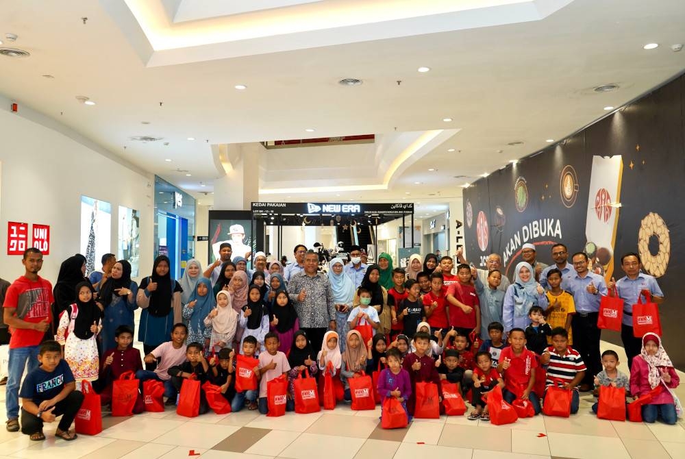 Seramai 58 anak yatim dan asnaf ambil peluang bergambar bersama Yahaya, pengurusan TDM dan Pertubuhan Sejahtera selepas selesai membeli pakaian Aidilfitri. - Foto TDM