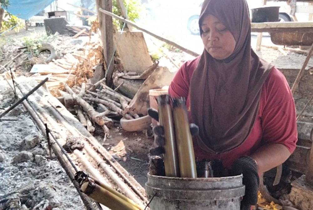 Sariwati menyusun lemang yang siap dibakar.