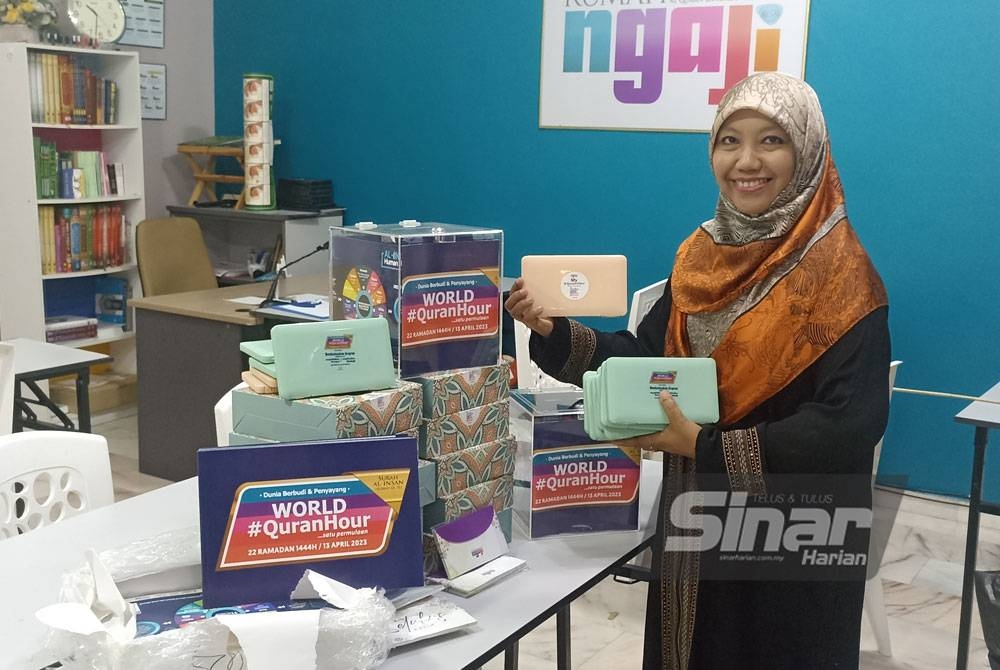 Roziah menunjukkan cenderamata dan plakad World #QuranHour bagi menyokong program yang akan diadakan Khamis ini.