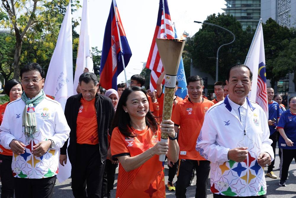 Sarun (kanan) bersama Hannah menyertai larian obor sempena Sukan SEA Kemboja di Putrajaya pada Selasa. - Foto Bernama