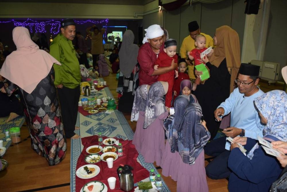 Norisham menyampaikan duit raya kepada anak-anak dari Pusat Jagaan Telaga Kasih Nur Muhammad, Kota Damansara.