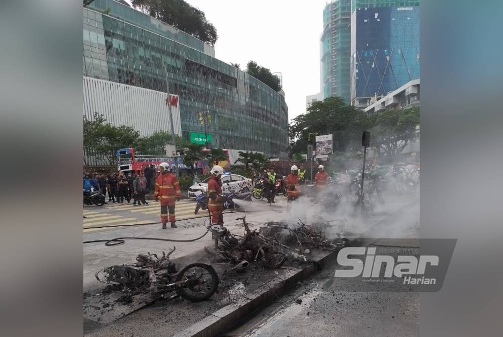 Anggota bomba sedang memadamkan kebakaran motosikal dan skuter elektrik di kawasan parkir pusat beli-belah Suria KLCC pada Khamis.