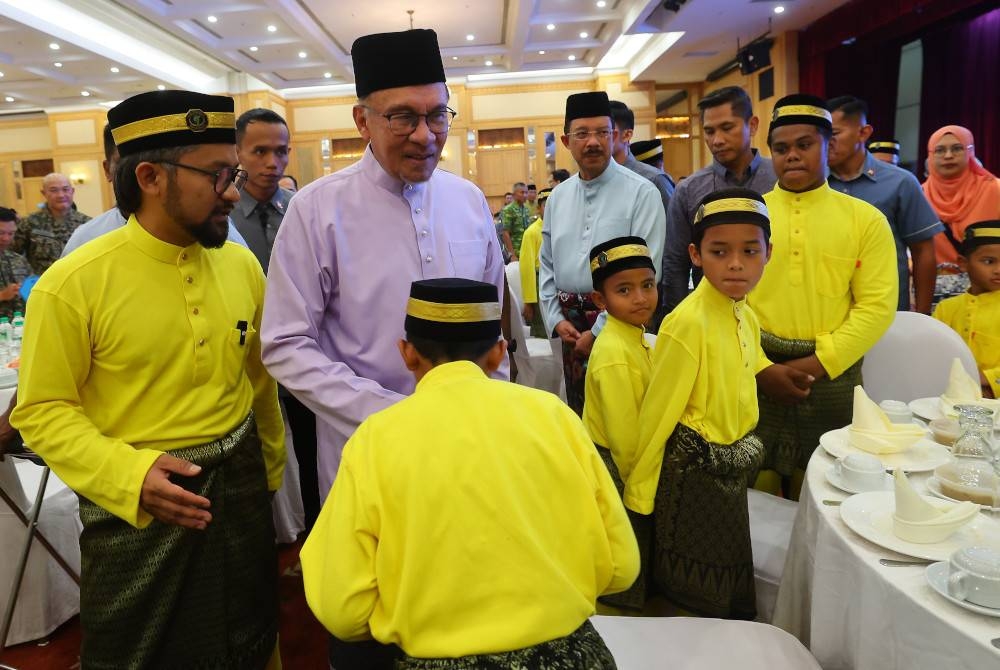 Anwar (tengah) beramah mesra bersama anak-anak yatim dari Rumah Pengasih Warga Prihatin pada Majlis Iftar Perdana Menteri bersama Jabatan Perdana Menteri dan Petugas Barisan Hadapan di Dewan De Seri Endon Puspanitapuri Presint 10 pada Khamis - Foto Bernama