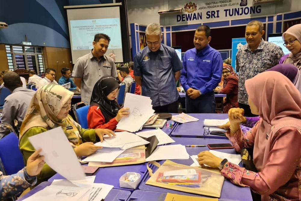 Syaiful Rizal (berdiri, dua dari kanan), Timbalan Pengarah Pendidikan Sektor Pembelajaran Jabatan Pendidikan Negeri Kelantan, Mohd Hassany (berdiri, dua dari kanan) beramah mesra bersama guru-guru yang menyertai Kursus Komprehensif Teknik Mudah Melukis Untuk Mata Pelajaran RBT di Dewan Sri Tanjong, JPN Kelantan.