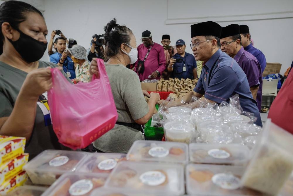 Dr Mohd Na&#039;im Mokhtar (kanan) menyampaikan pek makanan kepada golongan gelandangan pada Program Santuni Gelandangan Chow Kit di Pusat Pembelajaran dan Komuniti Chow Kit pada Jumaat. - Foto Bernama