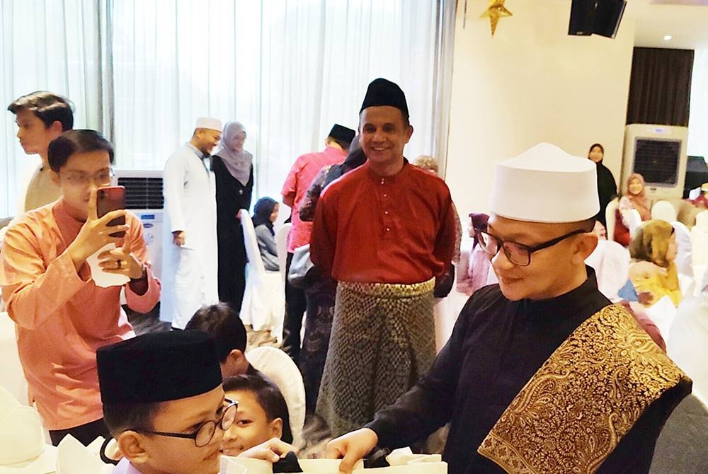 Muhamad Amin (kanan) menyampaikan sumbangan kepada golongan memerlukan pada Majlis Iftar Ramadan di sebuah hotel pada Jumaat.