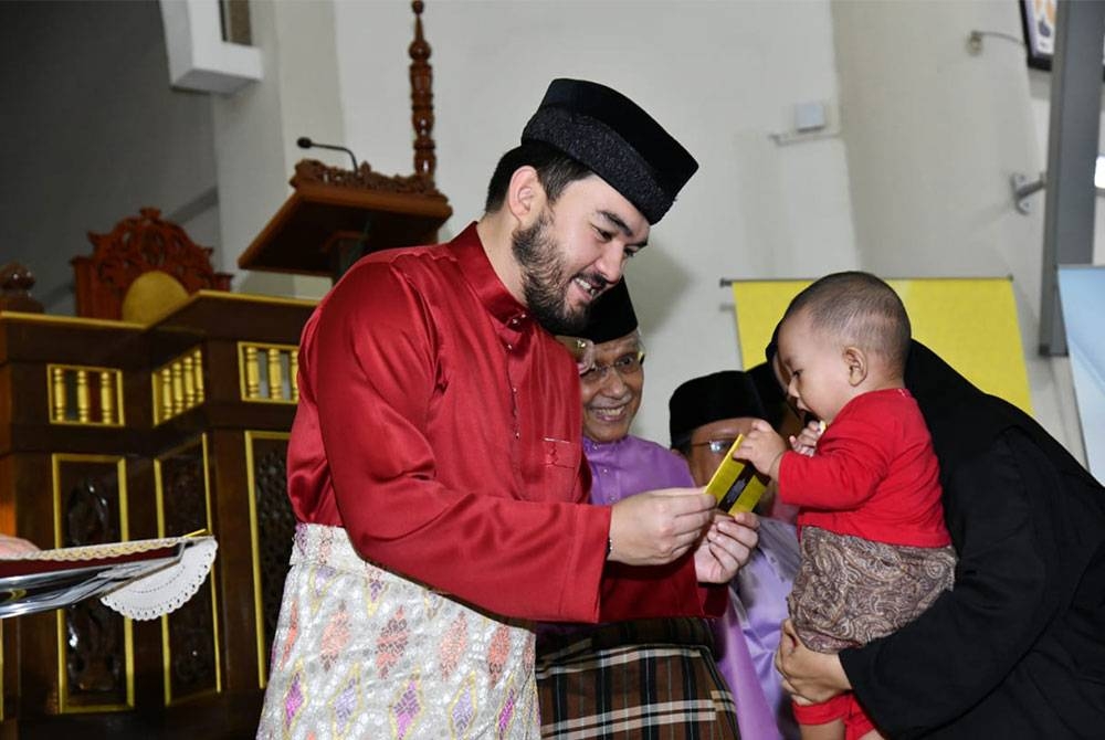 Tengku Amir Shah menyampaikan sumbangan Aidilfitri kepada salah seorang penerima cilik bagi daerah Petaling pada Sabtu.