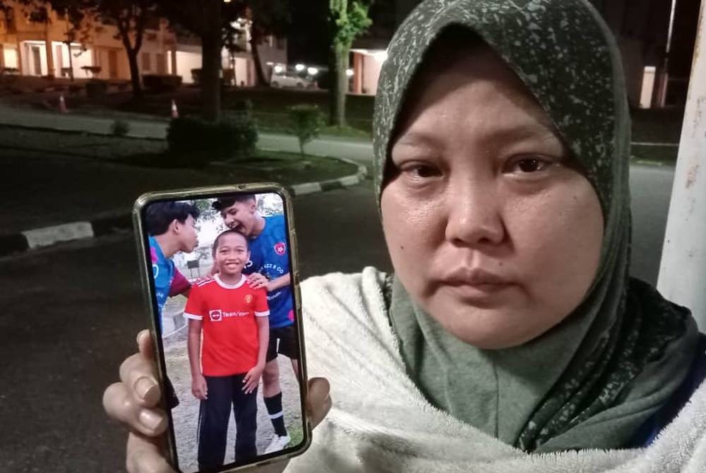 Ibu mangsa menunjukkan gambar Muhammad Khalifi yang lemas semasa mandi bersama jirannya di Sungai Pulau Jering, Kampung Bukit Tunggal, Segamat.