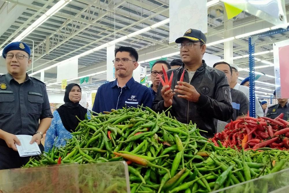 Azman (kanan) meninjau barang-barang kawalan ketika Sesi Tinjauan Mesra Pelaksanaan Skim Harga Maksimum Musim Perayaan Hari Raya Aidilfitri di sebuah pasar raya di sini pada Sabtu