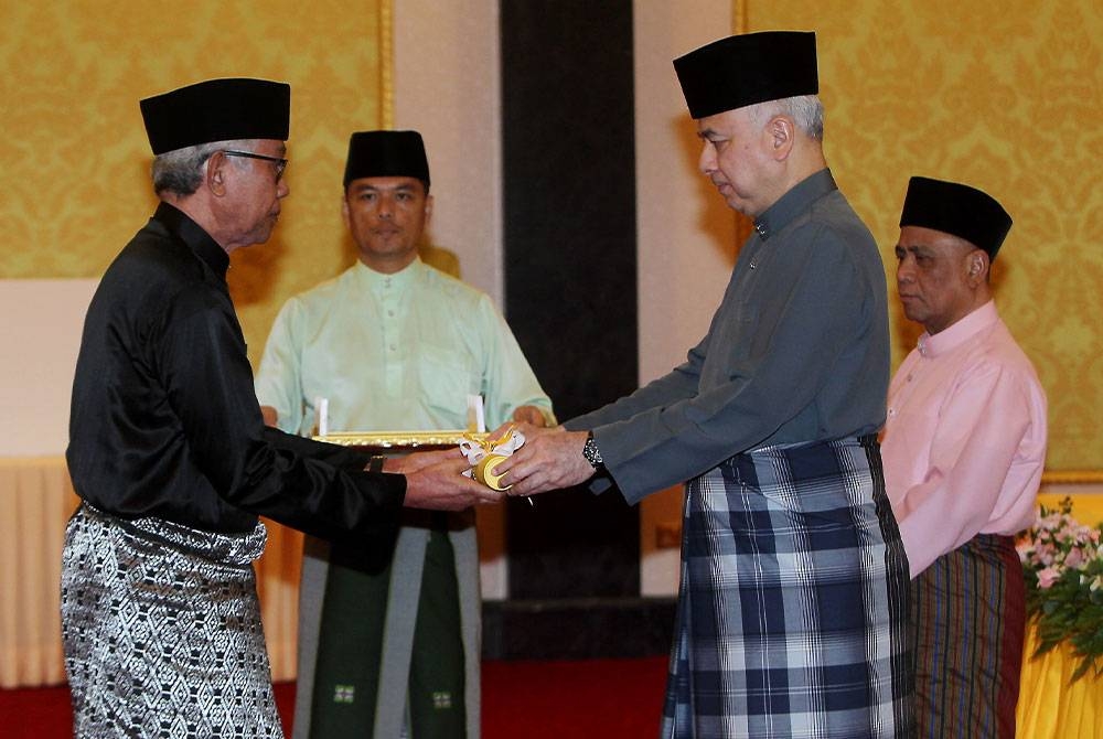 Sultan Nazrin (dua dari kanan) berkenan menyampaikan tauliah Hakim Negeri Perak kepada Zulkefli Ahmad (kiri) pada Majlis Berbuka Puasa Meraikan Pegawai-Pegawai Agama dan Masjid di Istana Iskandariah, Kuala Kangsar pada Sabtu. - Foto Bernama