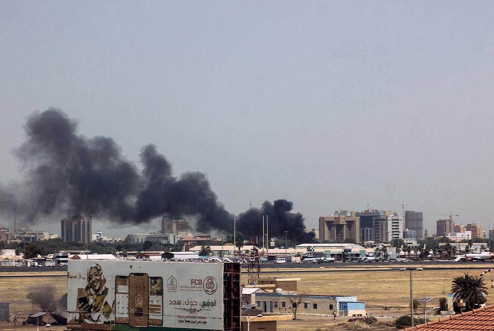 Asap tebal menyelubungi sebuah bangunan di lapangan terbang Khartoum. Foto AFP