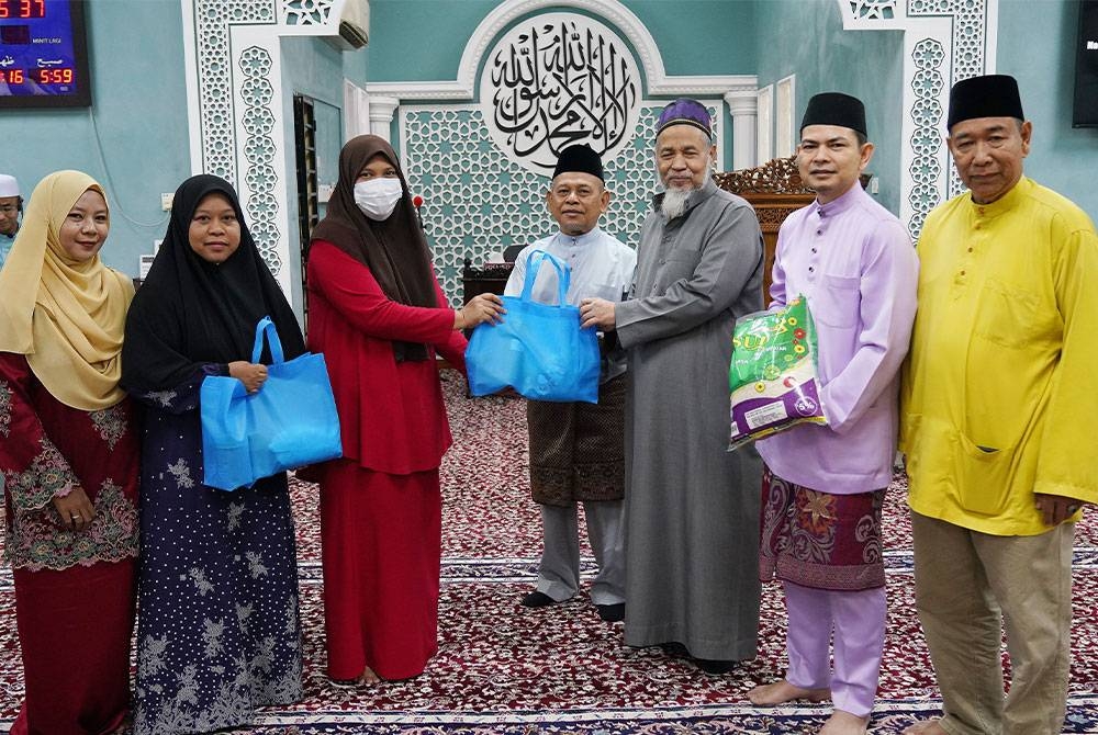 Zakaria (tiga dari kanan) menyampaikan sumbangan kepada penerima bantuan pada majlis Semarak Kasih Ramadan yang diadakan di Surau Al Muhajirin, Bukit Mahkota pada Sabtu. - Foto Rosli Talib