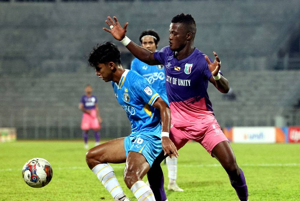 Pemain Kuching City FC Abu Kamara (kanan) cuba merampas bola daripada pemain Penang pada saingan pusingan 16 Piala FA di Stadium Negeri, Kuching pada Jumaat.