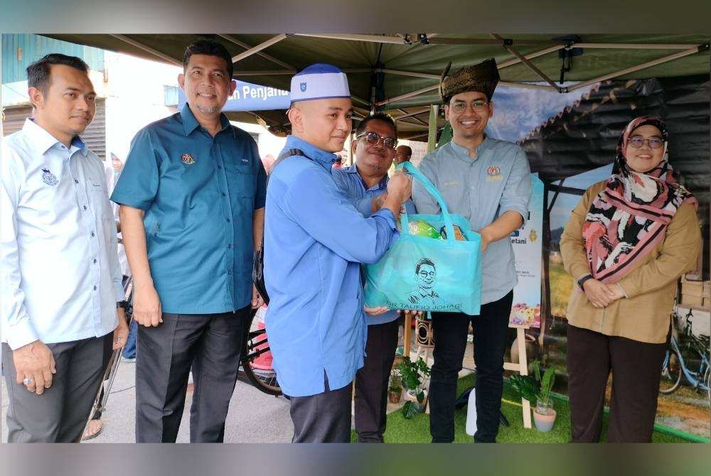 Mohammed Taufiq (dua dari kanan) menyampaikan sumbangan kepada golongan memerlukan sempena Program Jualan Syawal Madani di Pasar Tani Sungai Petani pada Ahad.