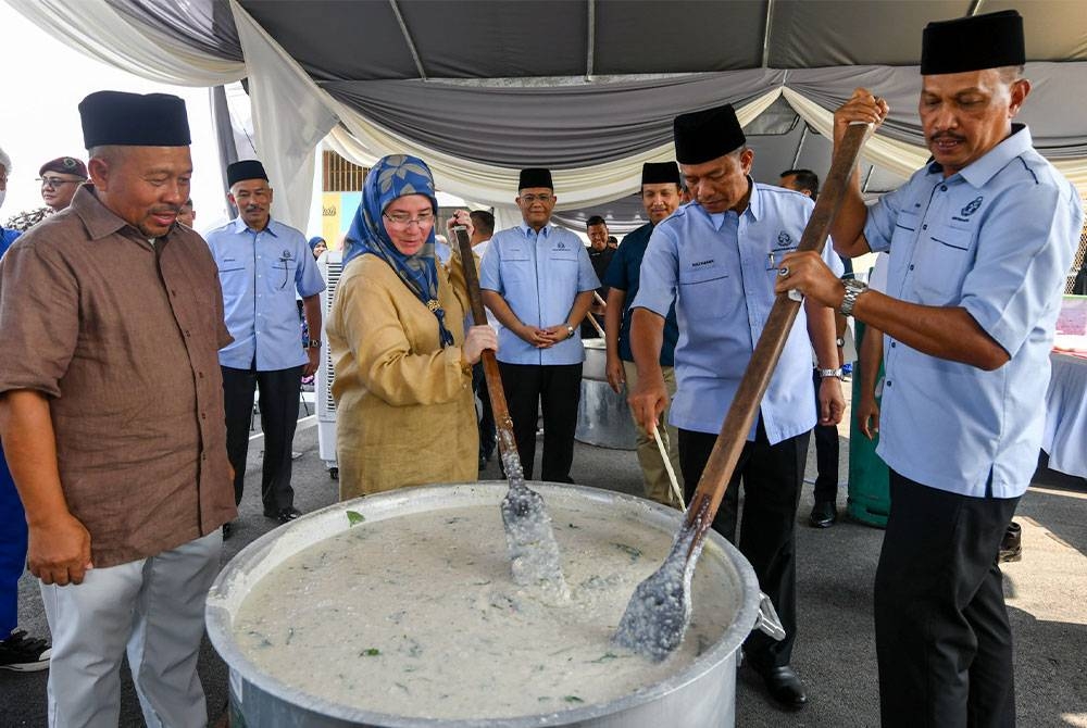 Tunku Azizah Aminah Maimunah Iskandariah berkenan memasak bubur lambuk ketika berangkat tiba mencemar duli pada Majlis Memasak Bubur Lambuk bersama warga Penjara Penor pada Ahad. - Foto: Bernama