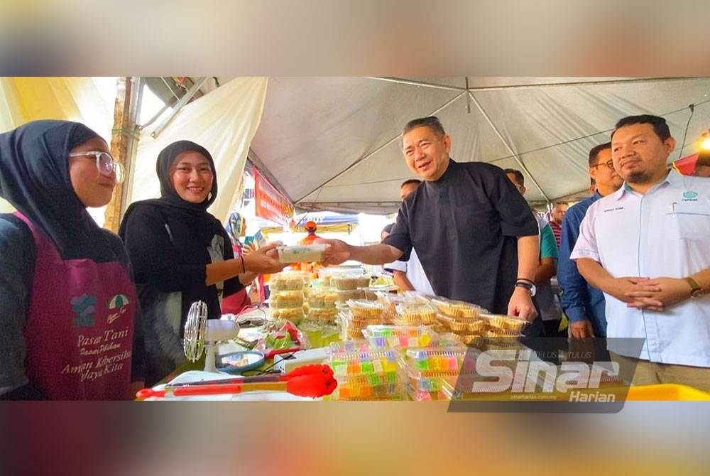 Salahuddin (dua dari kanan) menyampaikan bubur lambuk kepada peniaga yang menjual Menu Rahmah di Bazar Ramadan Rahmah Stadium Sultan Muhammad IV, Kota Bharu.