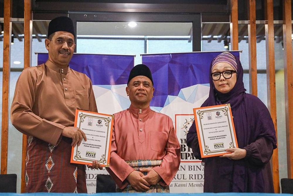 Saarani (tengah) menyaksikan pertukaran dokumen MoA antara Ismail mewakili YBUDR dan KGSB yang diwakili Fatima bagi melaksanakan Program Mahasiswa Perak Sejahtera 2030.