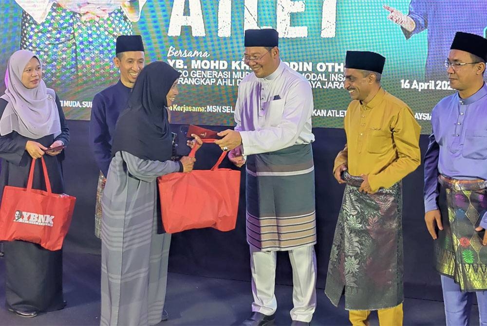 Mohd Khairuddin (tiga dari kanan) menyampaikan sumbangan kepada salah seorang penerima selepas Majlis Iftar Hargai Jasa Atlet 2023 di Dewan MPKS, Saujana Utama di sini pada Ahad.